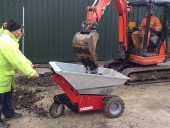 Electric powered Wheelbarrow being loaded by mini-digger