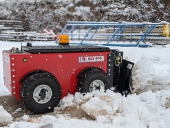 Radio-controlled MUV 4WD with plough attachment clearing snow